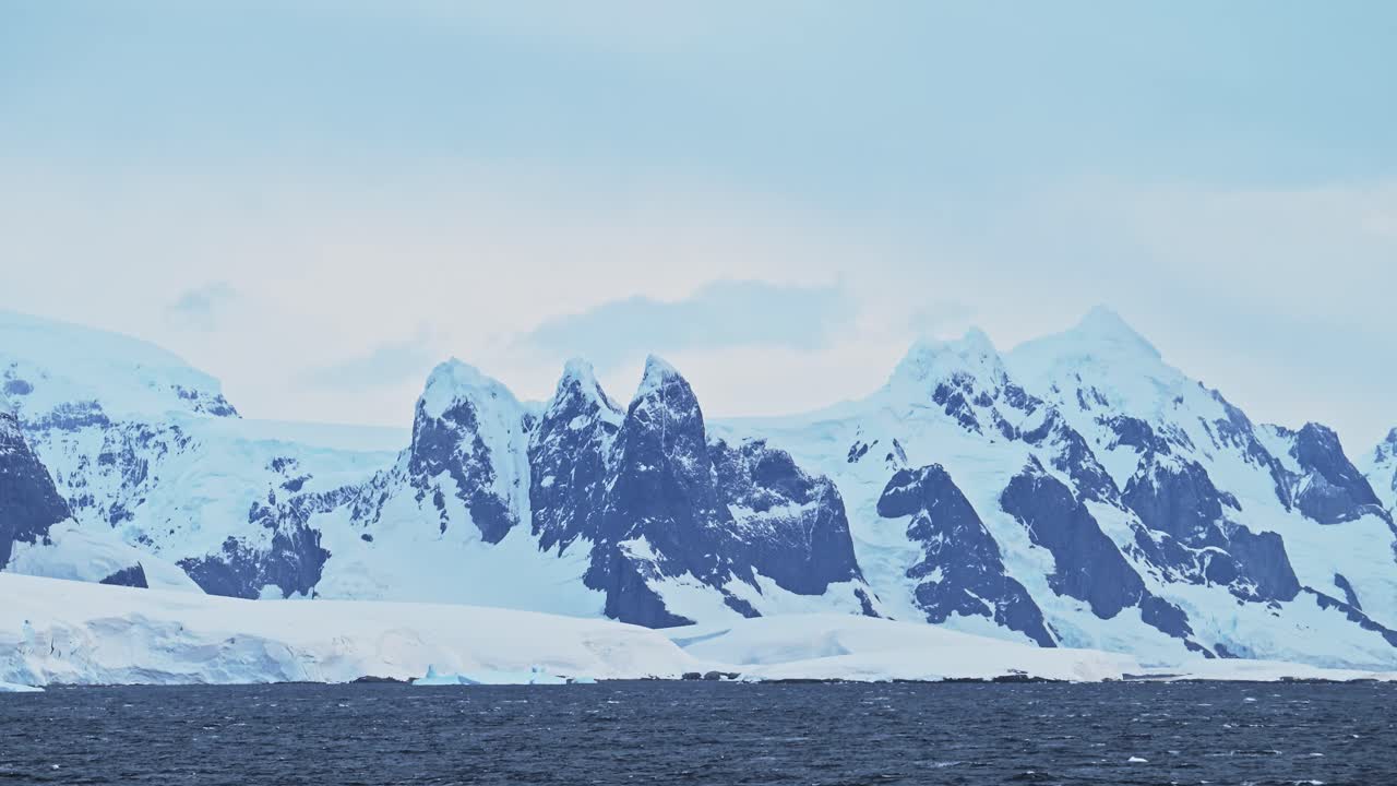 Antarctica Sunset Winter Mountains and Ocean with Dramatic Clouds and Sky, Amazing Scenery on Antarctic Peninsula Coast, Sunset Coastal Scenery in Icy Snowy Scene in Cold Weather