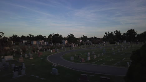 low aerial dolly above a graveyard with fading light