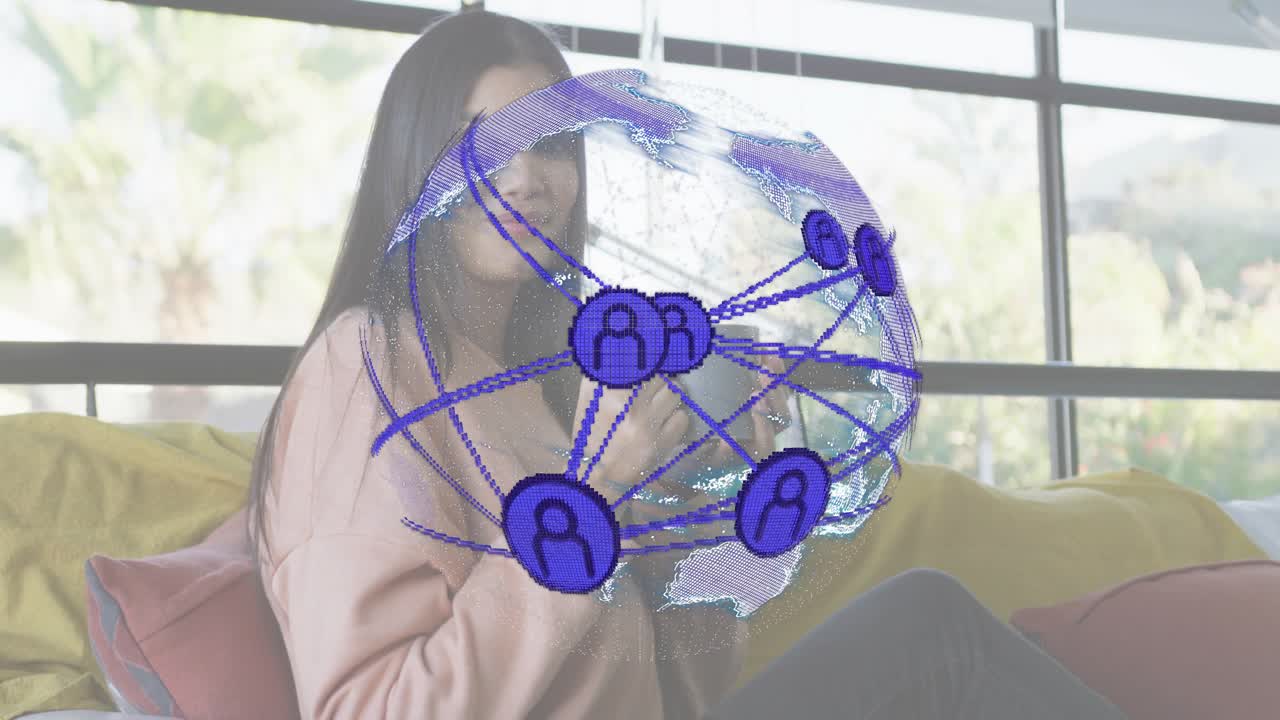 Mid adult woman tapping smartphone on yellow couch animating translucent tech globe for networking