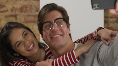 Caucasian-couple-taking-a-selfie-in-a-sofa