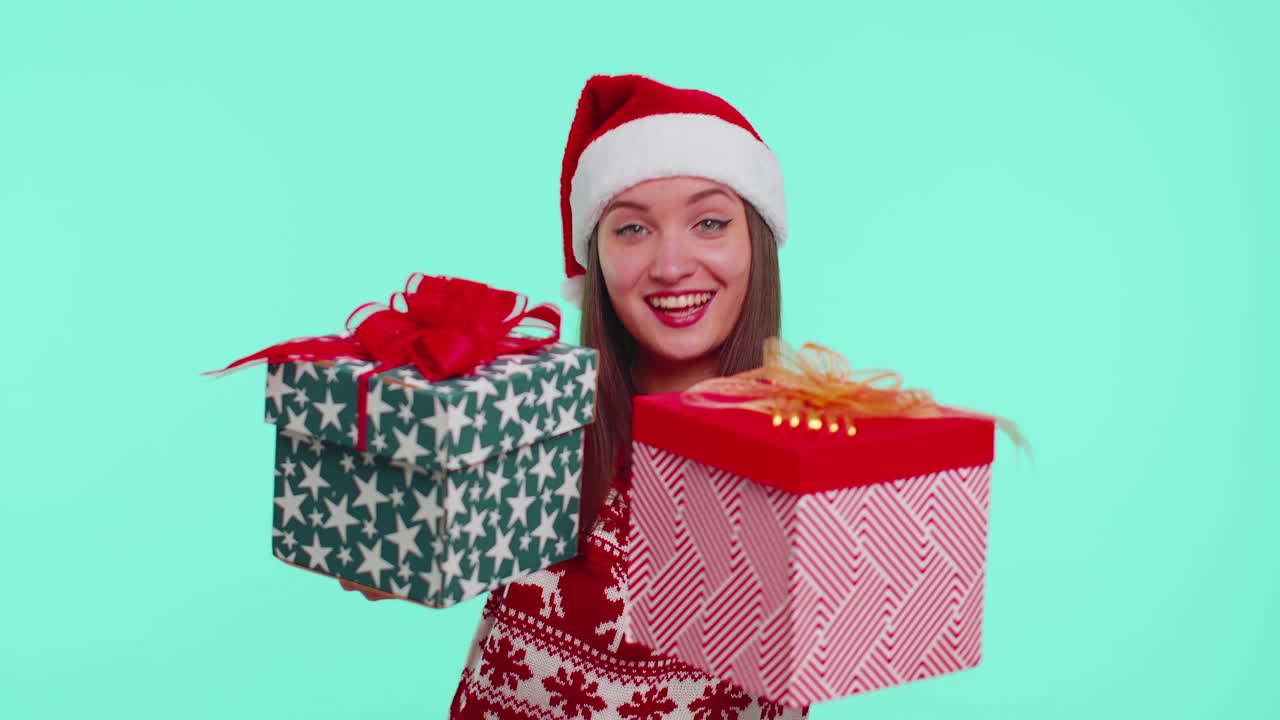 chica alegre en suéter de navidad rojo presentando dos cajas de regalos de navidad, compras víspera de venta de vacaciones