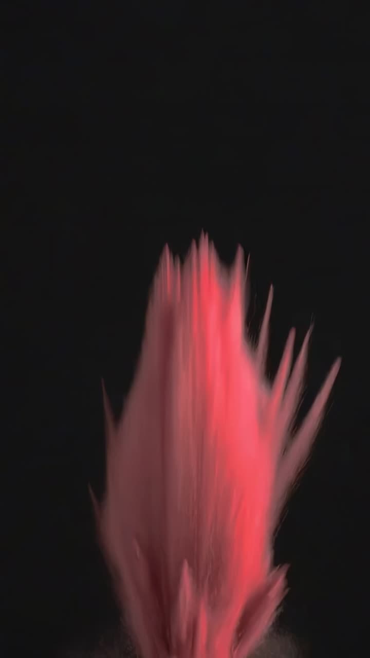 Vertical video: Erupting pink powder cloud from burst in studio, forming jet, shards for effect