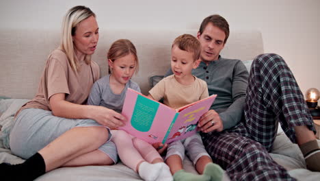 padres, niños y lectura de libros en el dormitorio