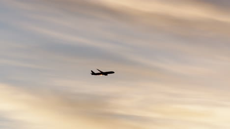 airplane silhouetted against a dramatic sunset sky