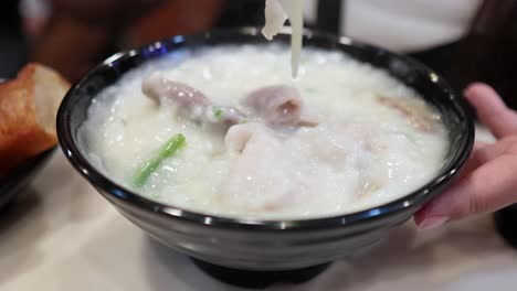 savoring a bowl of congee with toppings