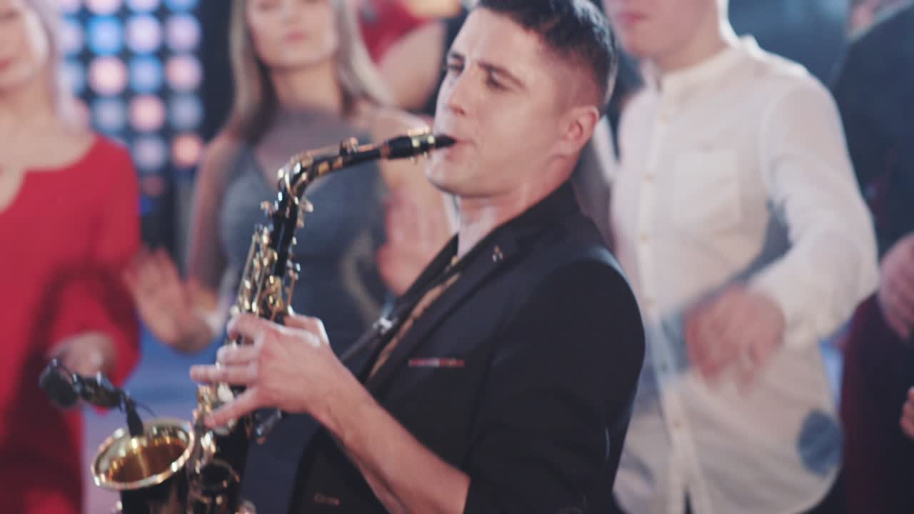 색소폰 연주자: 색소폰을 연주한다. 라이브 공연. 재즈 아티스트. 스포트라이트