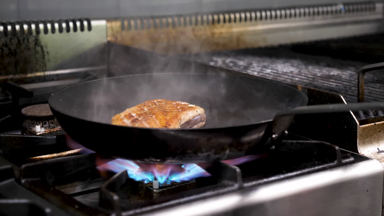 Kött som tillagas i en panna på en gasspis