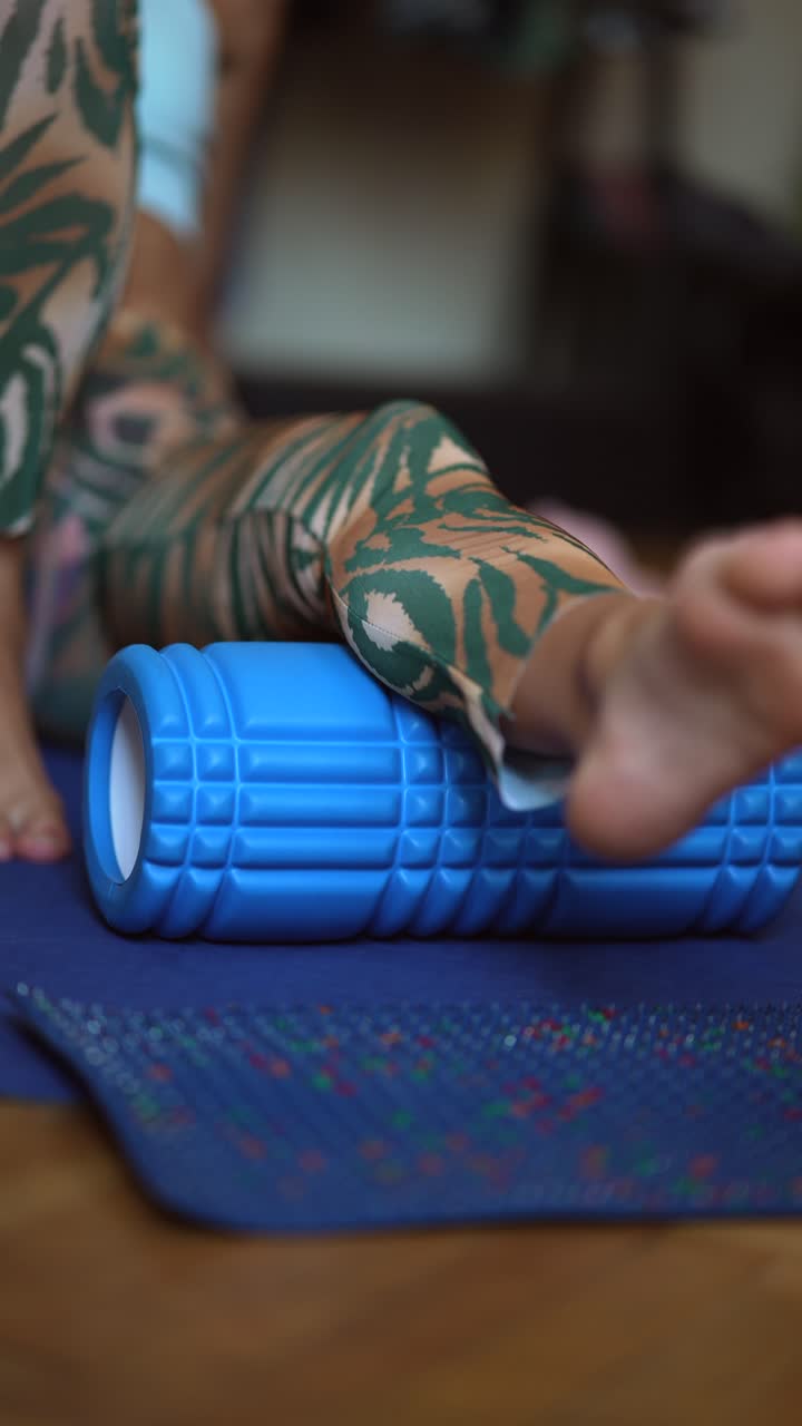mujer que usa un rodillo de espuma para estirar las piernas