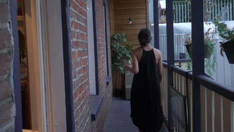 trendy young woman jumps through window on to balcony