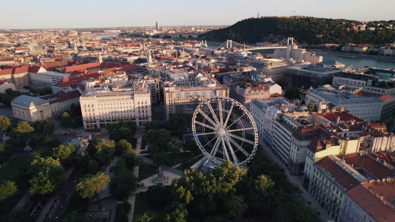 Una ruota panoramica a Budapest, circondata da edifici storici e una vista panoramica sul fiume.