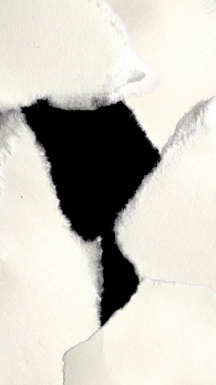White Paper Tearing Away to Reveal Black Background