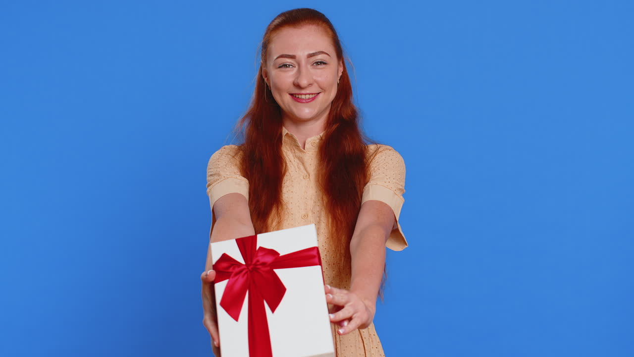Donna che presenta una scatola regalo di compleanno, tende le mani, offre un regalo incartato, festeggiando.