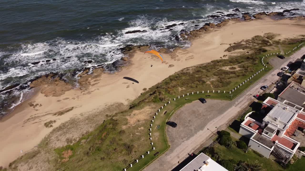 toma aérea de parapente volando sobre la playa de la pedrera en uruguay, sudamérica 4k
