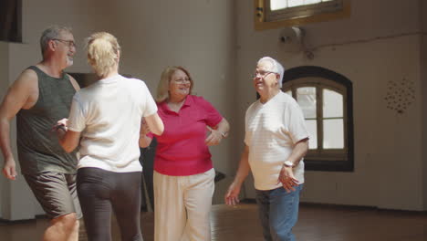 Long-shot-of-senior-couples-having-dance-class-in-ballroom