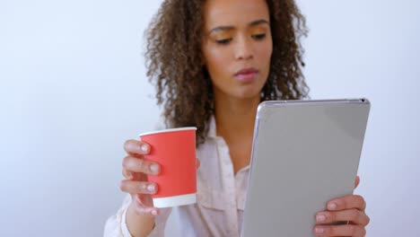 hermosa ejecutiva de raza mixta bebiendo café y usando tableta digital en una oficina moderna 4 4k