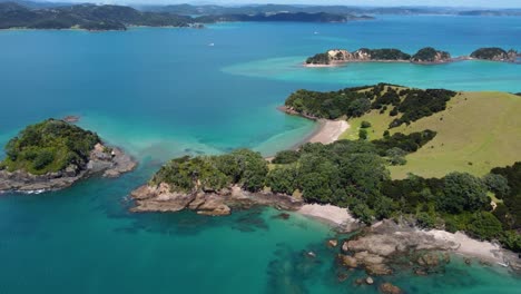aerial side panning shot of beautiful beaches in bay of islands, new zealand