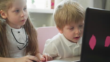 Little-boy-discusses-information-on-monitor-with-sister