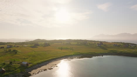 Midday-sun-shines-on-coastal-town-of-Holdoya-Norway-glimmering-across-sandy-bay