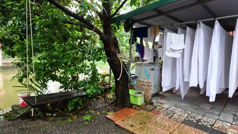 swinging by a riverside with laundry drying