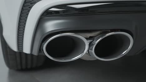 close-up of a white car's dual exhaust pipes