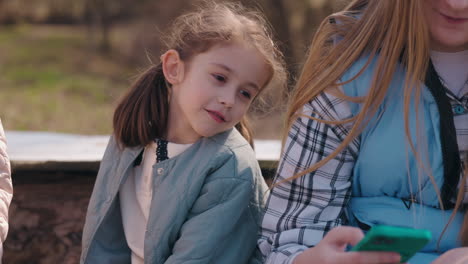 children using a smartphone outdoors