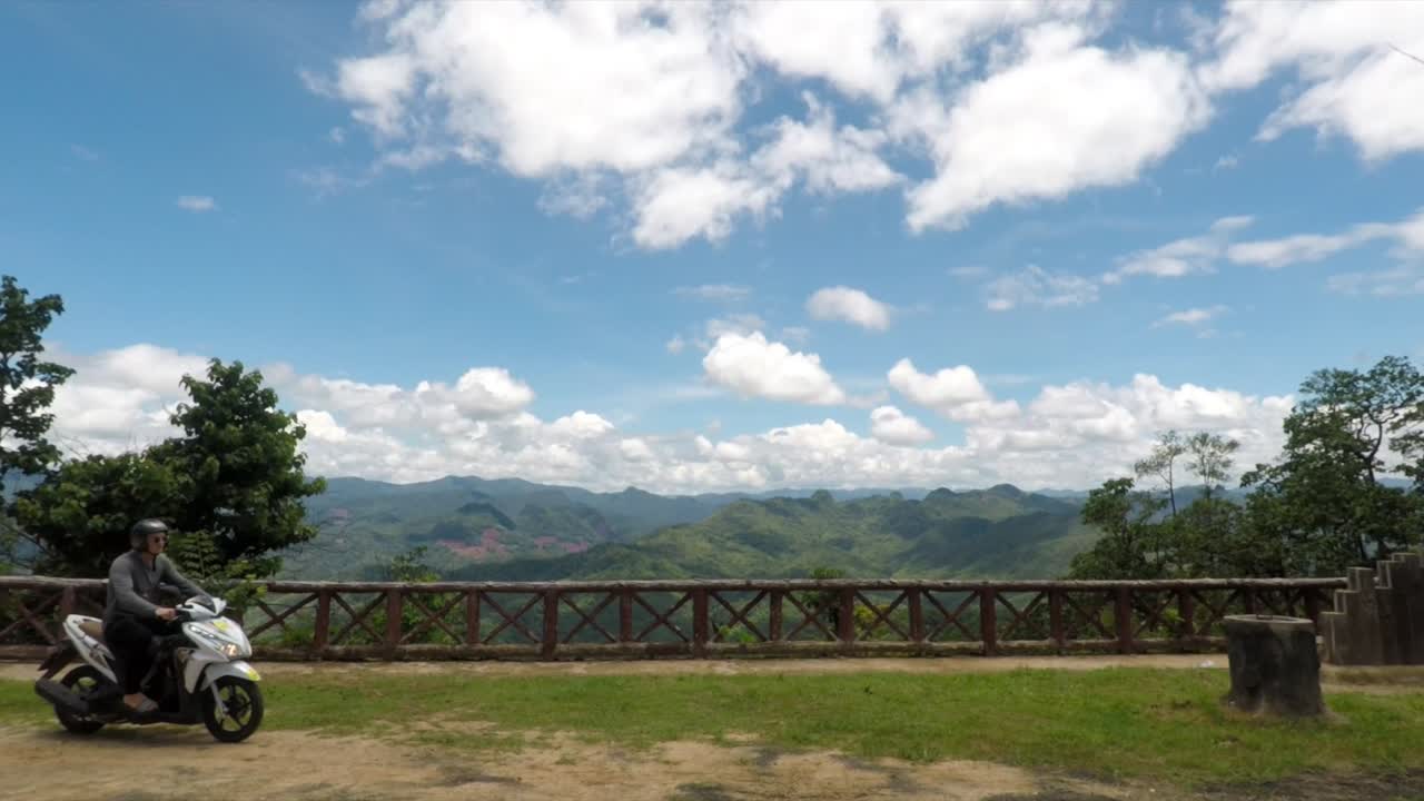 Riding a Motorbike Overlooking Mountains.