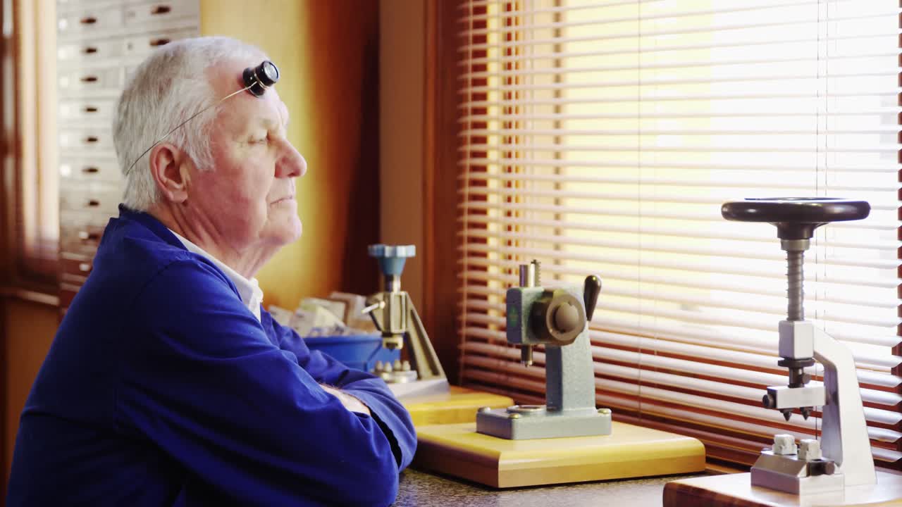 워크 ⁇  에 앉아서 미소 짓고 있는 시계 전문가