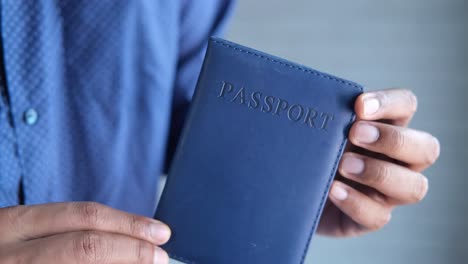 man holding a blue passport