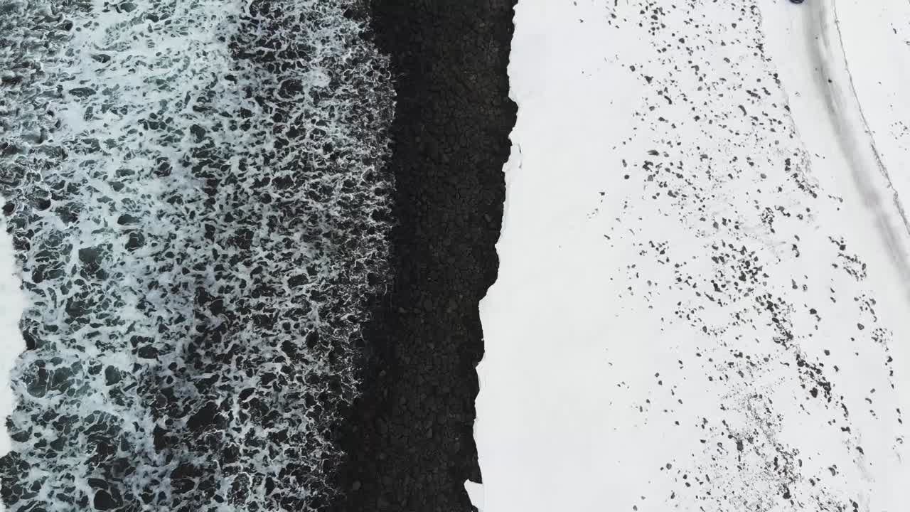 Drone view of the ocean waves in a snowy landscape