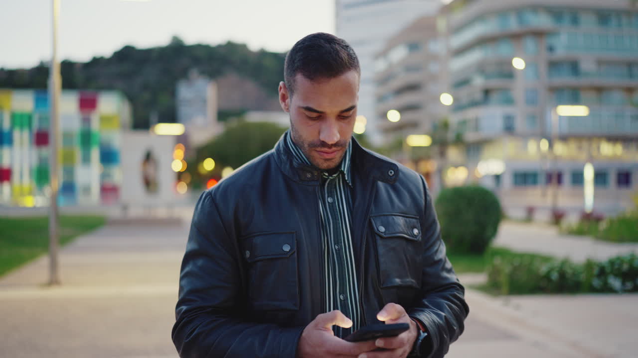 Young man dressed casual using mobile phone outdoors.