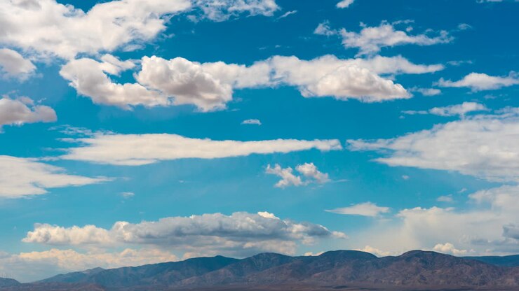 Nubes de ensueño formándose y siendo arrastradas por el viento sobre las montañas desérticas - lapso de tiempo.