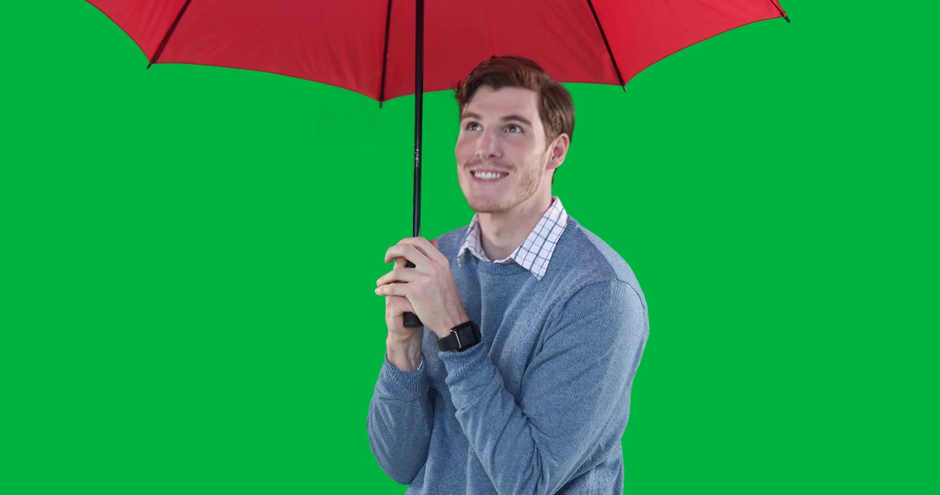 Giovane uomo che apre un ombrello rosso su schermo verde