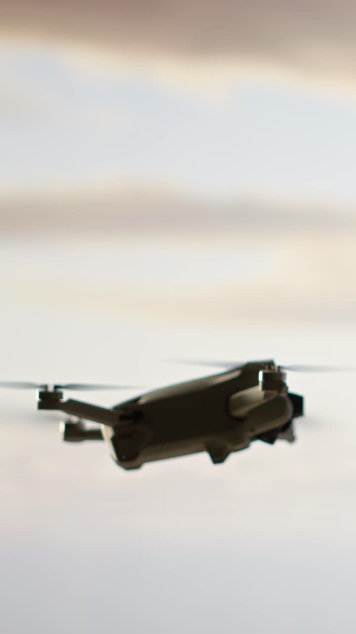 Moderni drone lentää ja pyörii vuoristoisella taivaalla.