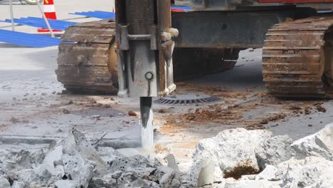 demolition of concrete with jackhammer and excavator