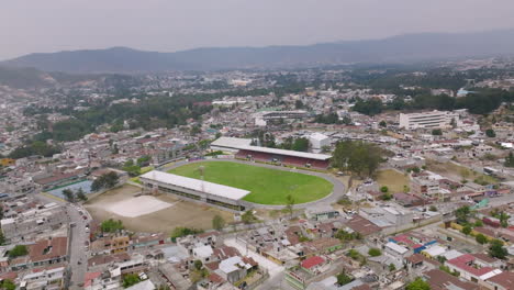 wide aerial flyover of a small soccer stadium in huehuetenango, guatemala