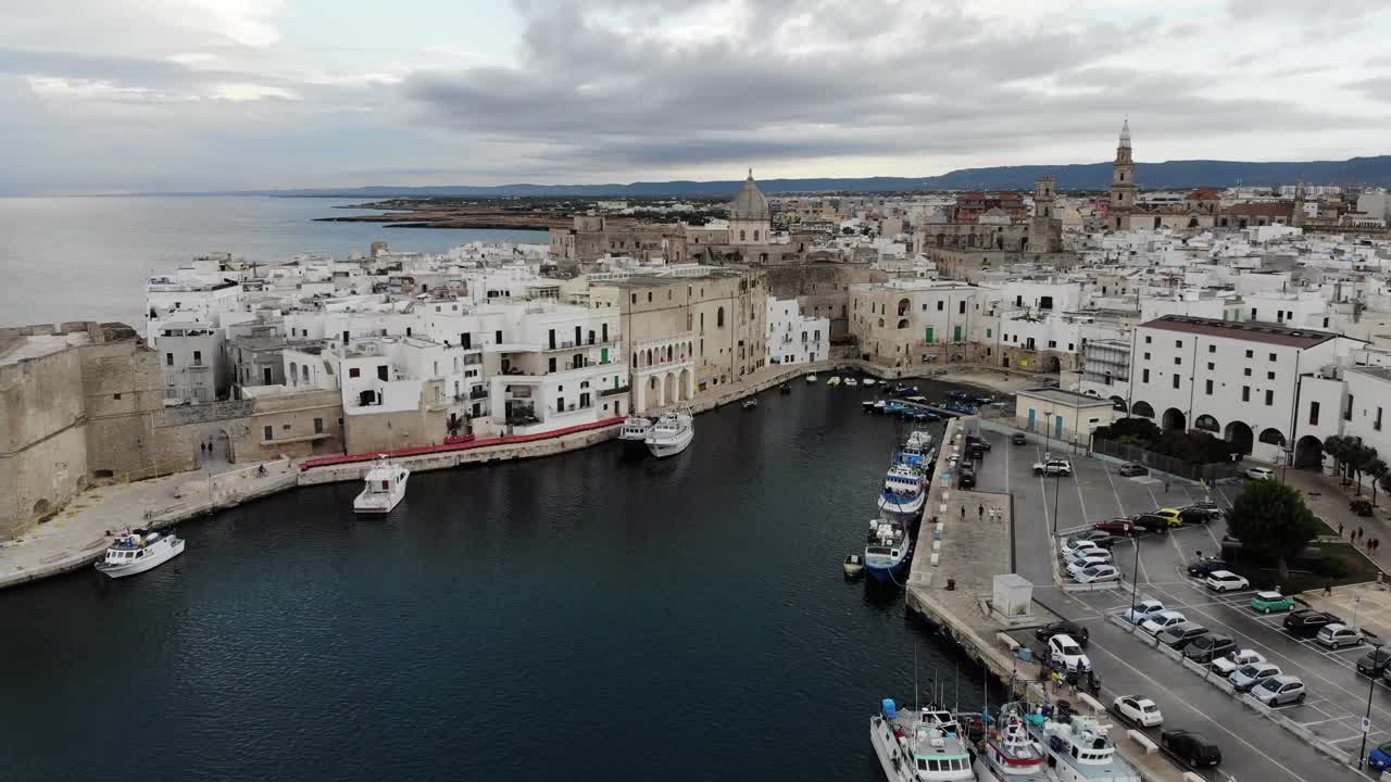 Drone slowly reveals the Monopoli old city with a  left rotation movement  during the dawn