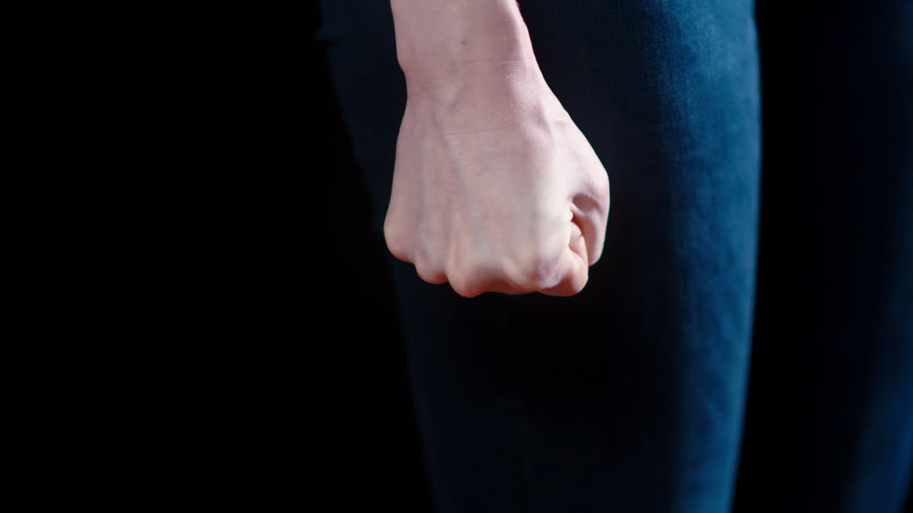 una mujer caucásica aprieta el puño