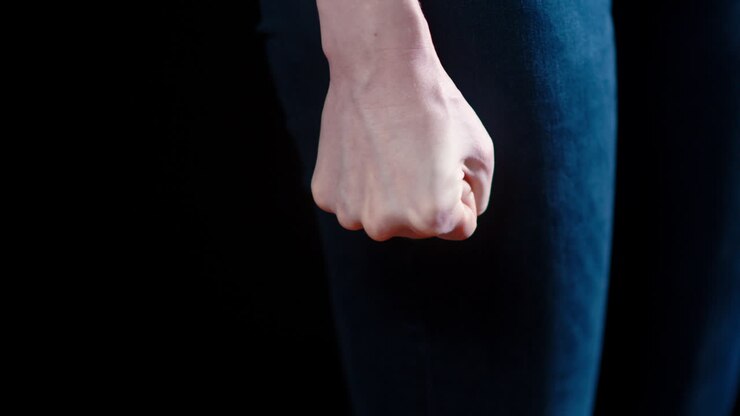A caucasian woman clenches her fist