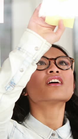 mujer de negocios asiática mirando notas adhesivas