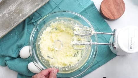 making a dessert called red raspberry tea cake made with fresh berries and vanilla buttercream frosting. great for tea parties. adding almond extract to the mixing bowl and combining the ingredients