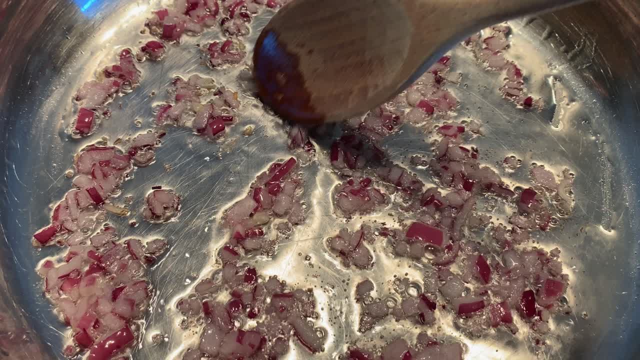 freír las cebollas en aceite caliente en una sartén en una estufa eléctrica