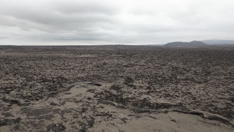 barren lava fields in reykjanes peninsula, iceland, low aerial view on overcast day