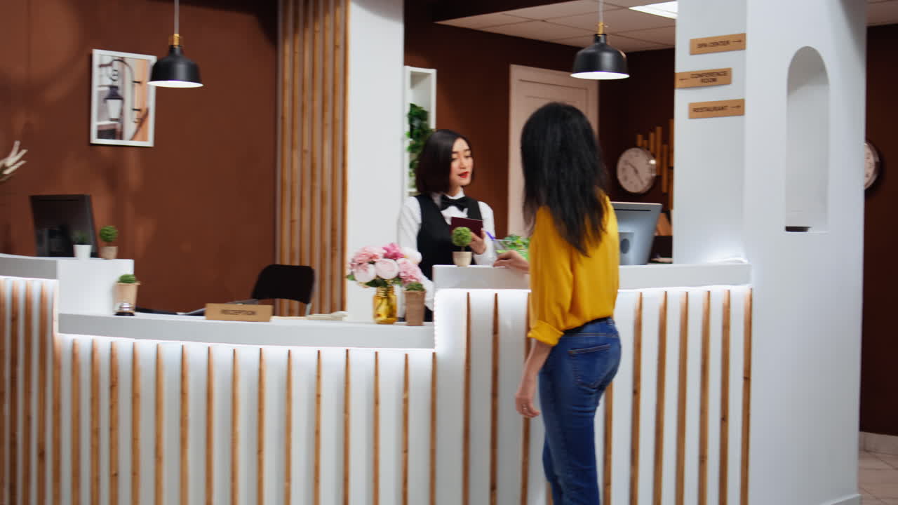 el personal del hotel comprueba la información del pasaporte para el check-in en la recepción.