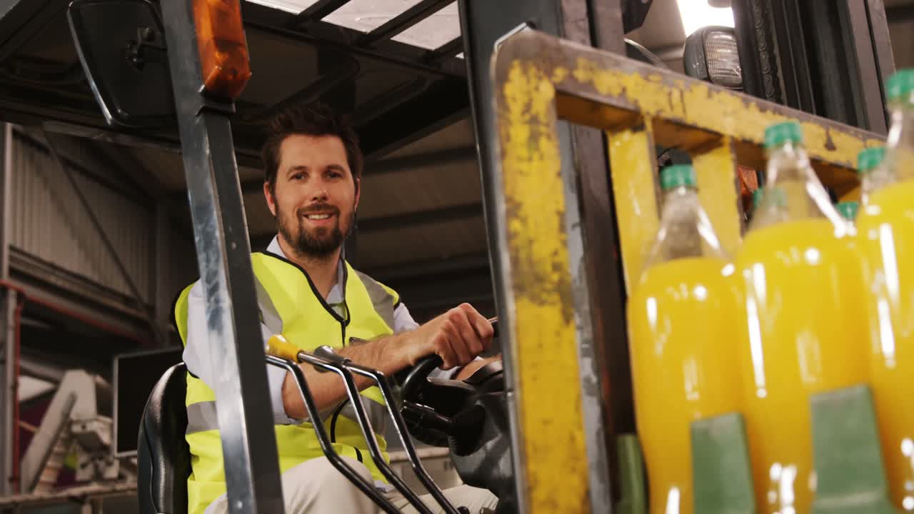 Operaio che trasporta bottiglie con un carrello elevatore in un'industria di imbottigliamento