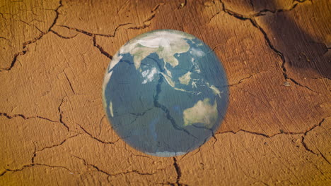 lapso de tiempo de una superposición de globo planetario giratorio en el fondo de la tierra seca y agrietada