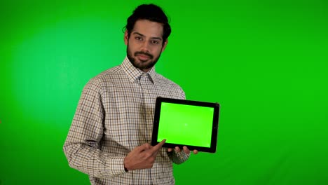 guy-using-mobile---tablet-with-green-screen-and-green-background-indian-guy-with-green-screen