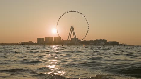 unsurpassed sunset over the biggest ferris wheel in dubai marina uae.