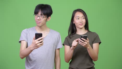 young asian couple using phone together