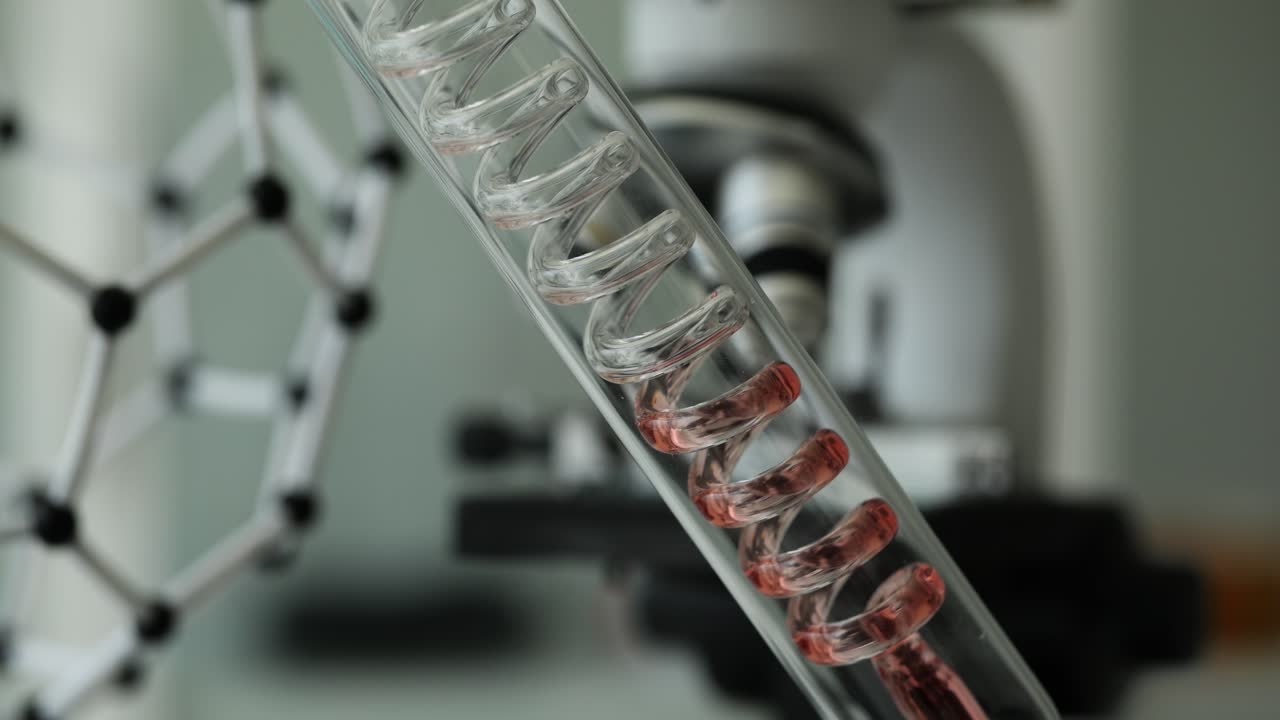 Experimental setup with red liquid in spiral plastic tube