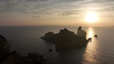 rising aerial view sunrise behind medes islands golden shimmering mediterranean sea horizon